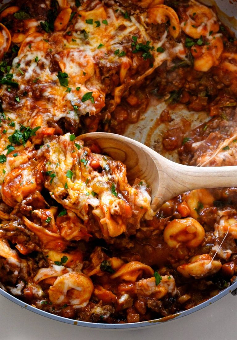 Tortellini with sausage in a skillet.
