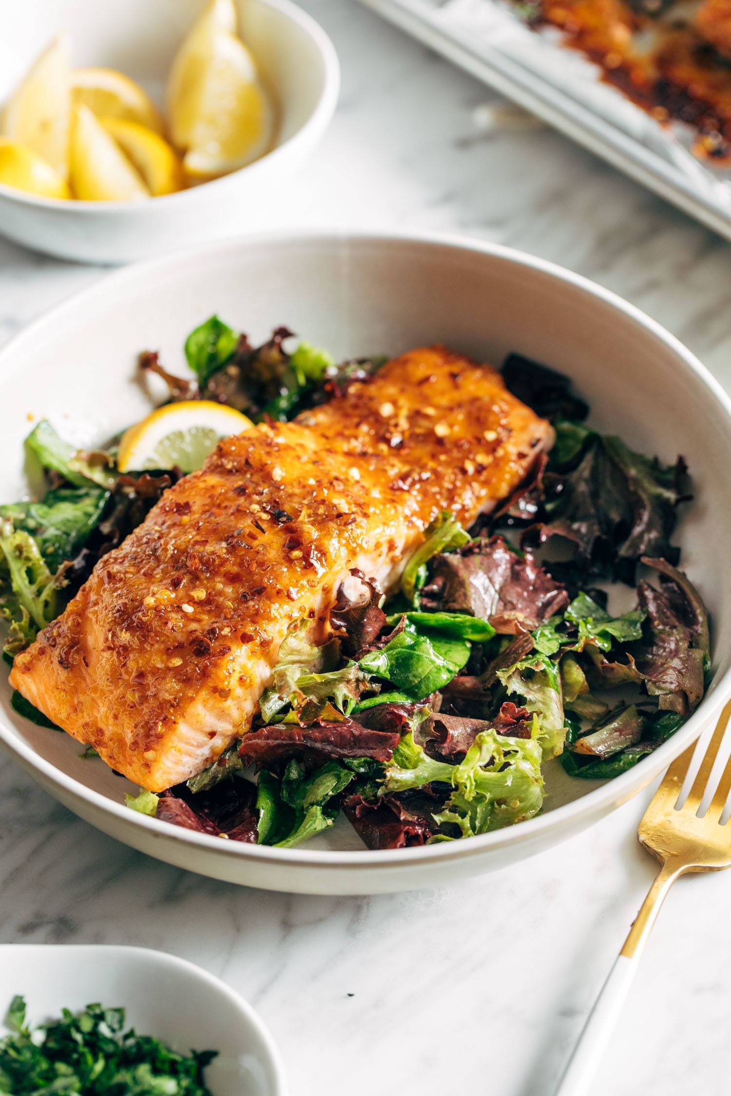 Hot honey salmon in a bowl with salad.