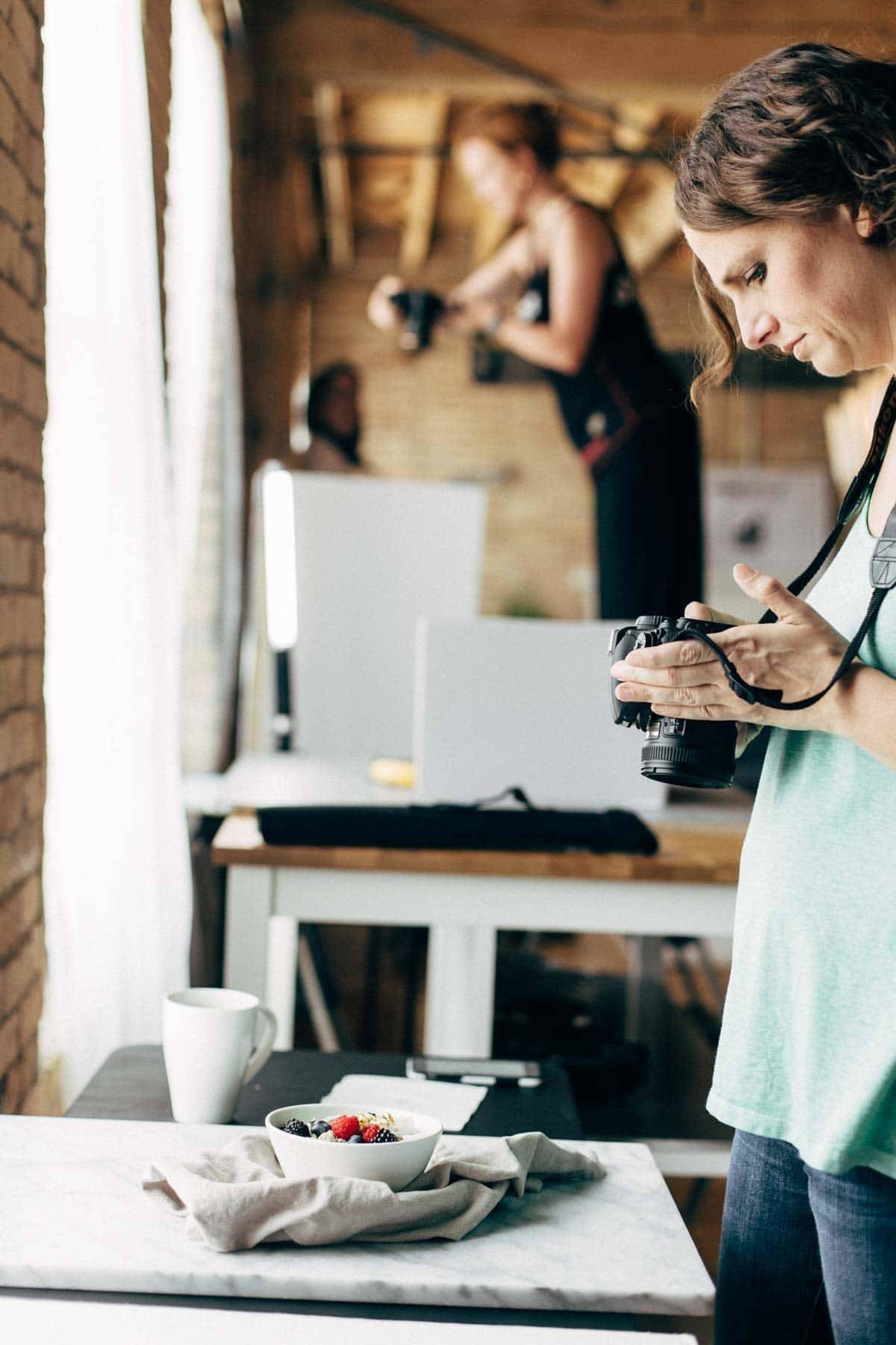 Woman looking at a camera in front of a table with food.